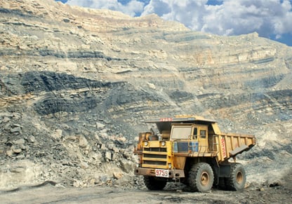 A cargo carrying truck in front of a rocky landscape