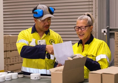 A man and a woman sort through tested gold samples in a laboratory. 